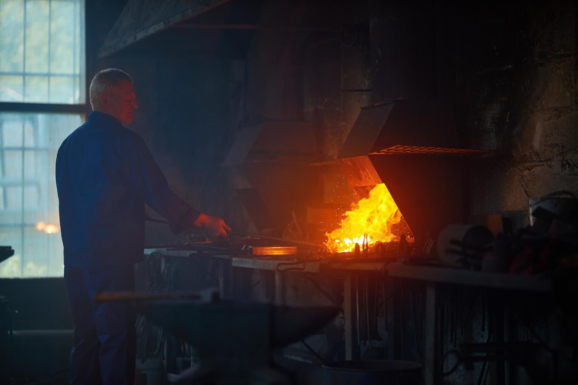Operador industrial realiza etapa de aquecimento do metal em ambiente fabril, representando o processo de fundição de precisão com controle térmico e foco na qualidade das peças