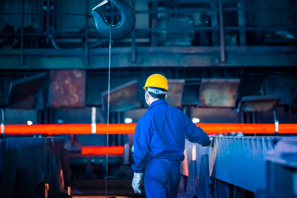 Forno industrial em operação na fundição de precisão, com metal aquecido sendo moldado em processo controlado da indústria, evidenciando alta temperatura e precisão técnica na fabricação de peças metálicas.