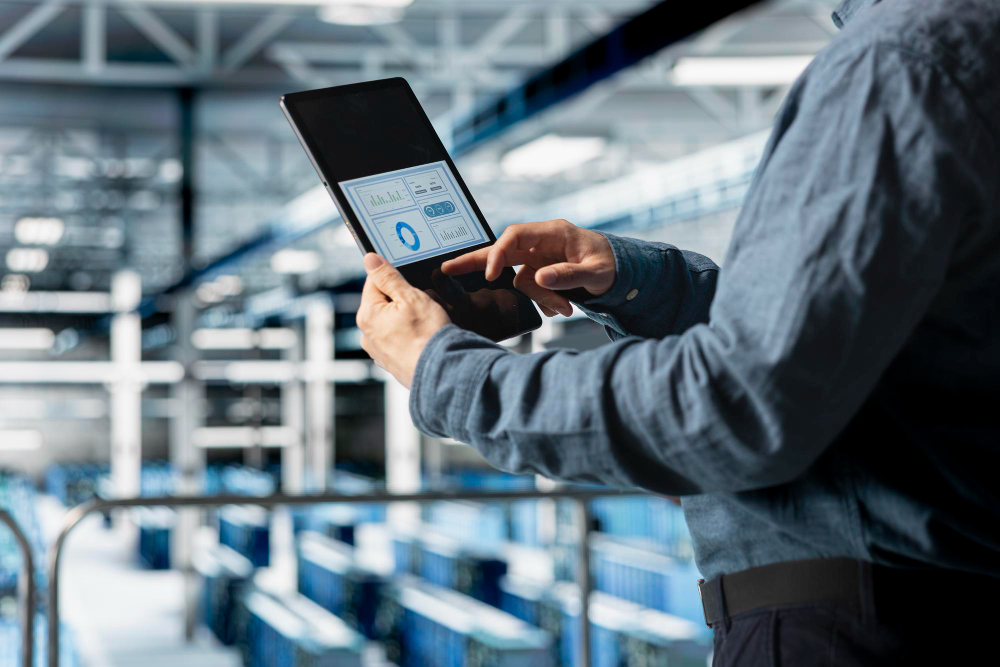 Profissional monitorando dados de produção em tablet no ambiente industrial, ilustrando controle e rastreabilidade na microfusão.