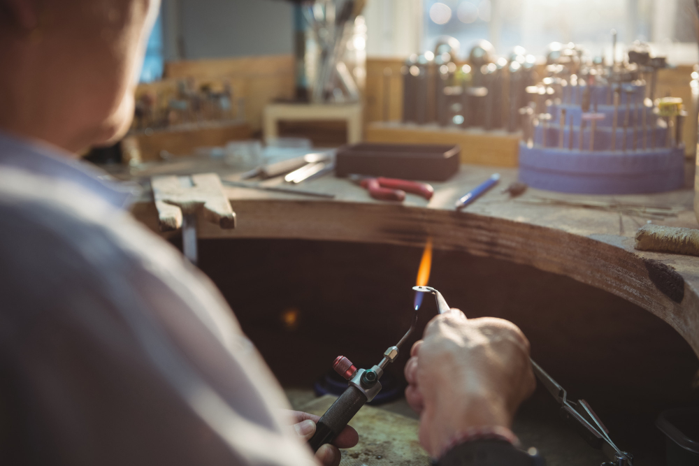 écnico realizando ajuste manual de peça metálica, ilustrando a comparação entre fundição de precisão e usinagem em etapas de fabricação e acabamento industrial.